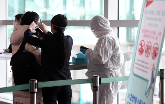 신종 코로나바이러스 감염증 공포가 확산하는 가운데 지난달 29일 인천국제공항 제1터미널 입국장에서 중국 텐진발 입국한 사람들이 검역을 받고 있다. [중앙포토]