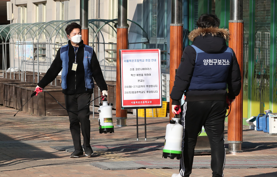 학부모 한 명이 신종 코로나바이러스 감염증 능동감시 대상자로 분류돼 4일 휴업에 들어간 서울 양천구 목운초등학교에서 양천구 보건소 관계자들이 교내 방역 작업을 하고 있다. [연합뉴스]