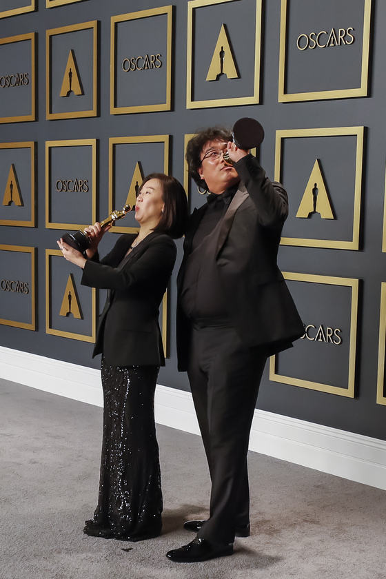 작품상 트로피로 술마시는 시늉을 하는 곽신애 대표와 봉준호 감독. [EPA=연합뉴스]