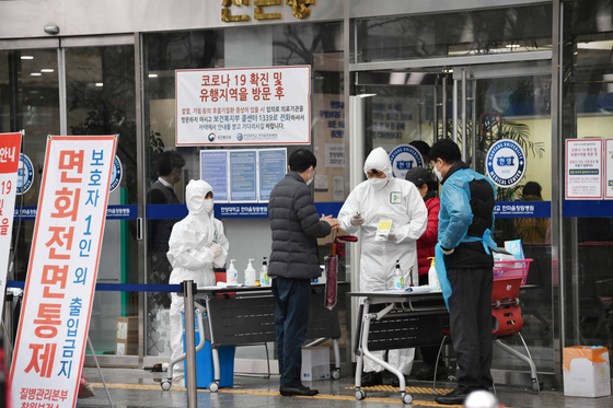 코로나19 확진자 발생으로 병원이 폐쇄된지 4일만 25일 오전 창원시 성산구 한마음창원병원 외래진료가 시작됐다..직원들과 질병관리본부 관계자가 출입자 발열검사와 손소독 등을 하고 있다. /김구연 기자 sajin@idomin.com