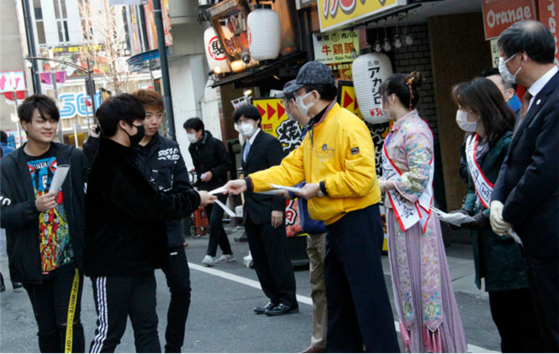 일본에 거주하는 중국 화인들이 도쿄에서 일본을 돕자며 마스크를 나눠주는 행사를 벌이고 있다. [중국 인민망 캡처]