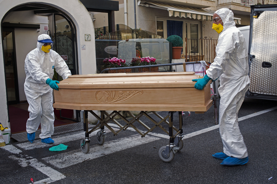 지난 1일 이탈리아 리구리아주 라이젤리아의 한 호텔에서 신종 코로나로 사망한 87세 환자의 시신이 든 관을 방호복을 입은 의료진이 이송하고 있다. [AP=연합뉴스]