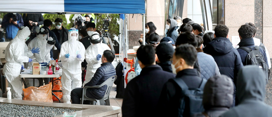 이달 10일 서울 구로구 신도림동 코리아빌딩 앞에 마련된 선별진료소에서 입주자들을 비롯한 주변 직장인들이 코로나19 검진을 받는 모습. 뉴스1