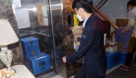 21일 서울 마포구 정의기억연대 사무실에서 검찰이 압수수색 물품을 옮기고 있다. 연합뉴스