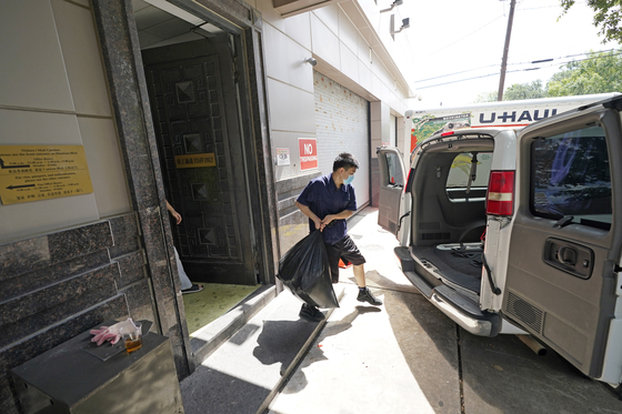 미국 텍사스주 휴스턴에 있는 중국 총영사관 건물 뒤편에서 한 남자가 화물 차량에 짐을 싣고 있다. 공관을 닫지 않겠다는 차이 웨이 총영사 말과 달리 페쇄를 위한 준비가 진행 중인 것으로 보인다. [AP=연합뉴스]