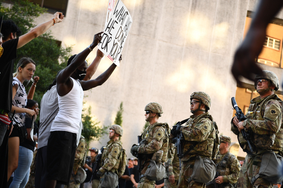 6 월 20 일 (현지 시간) 방위군은 미국 오클라호마 주 털사에서 열린 인종 차별 반대 시위를 보류하고 있습니다.  이러한 국내 시위에서 미군을 동원하는 정치적 장단점은 분열되어있다. [AFP=연합]