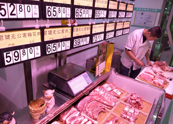 지난해 12 월 9 일 중국 베이징의 한 정육점에서 고기 가격이 위태로워졌다.  지난해 중국 전역을 휩쓴 아프리카 돼지 열병으로 돼지 고기 가격이 급등했다.  돼지 고기가 중국인의 주원료이기 때문에 중국 당국도 긴급 상황에 처했습니다. [로이터=연합뉴스] 