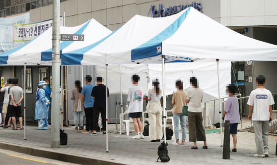 21 일 오전 서울 성북구 보건소에 마련된 신종 코로나 바이러스 감염증 (코로나 19) 검진 클리닉을 찾은 시민들이 줄을 서서 검사를 기다리고있다.  연합 뉴스