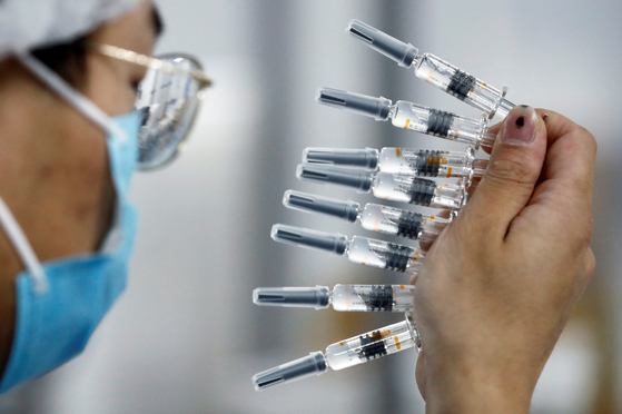 In Beijing, China, a researcher from the pharmaceutical company Sinobac is testing the quality of the COVID-19 vaccine that is being developed. [로이터=연합뉴스]