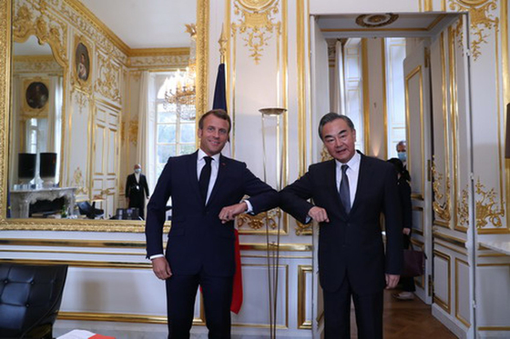 Wang Yi, who toured Europe at the end of August, meets with French President Emanuel Macron, a member of the Council of State and foreign minister, to salute him with his elbows. [중국외교부 홈페이지 캡처]