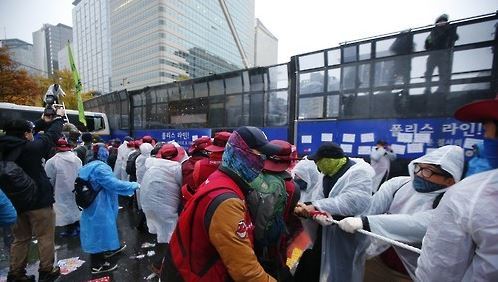 Protesters trying to tear down the wall of the police car at the site of the protests against the general uprising of the people on November 14, 2015. [연합뉴스]