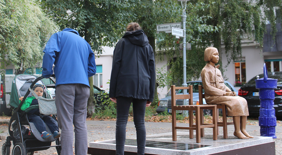 On the 25th of last month (local time), citizens are reading the inscription written in the 'Peace of the Girl', which was installed in the German capital, Berlin. [연합뉴스]