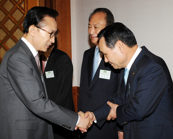 In May 2010, at the Blue House inviting financiers to a luncheon, then-Chairman Lee Myung-bak (left) shakes hands with then-Chairman Lee Pal-seong of Woori Financial Group. [청와대사진기자단]