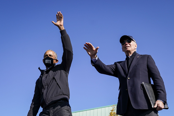 버락 오바마 전 대통령이 지난 31일(현지시간) 조 바이든 민주당 대선후보와 함께 미시간주에서 열린 드라이브 인 유세장에 나타나 지지자들에게 손을 흔들고 있다. [AFP=연합뉴스]