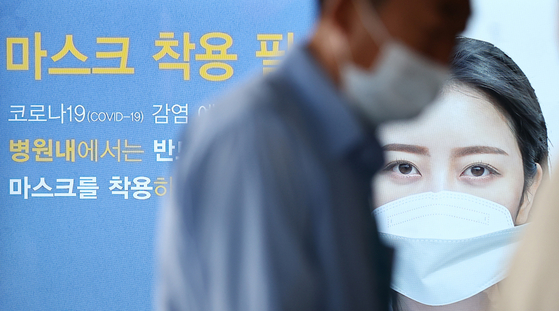 Visitors walk with masks at Seoul National University Hospital in Jongno-gu, Seoul, on the afternoon of last month 13, when it became mandatory for users and workers of public transportation, medical institutions and nursing facilities to use masks in accordance with the Infectious Disease Prevention Act.  Yunhap news