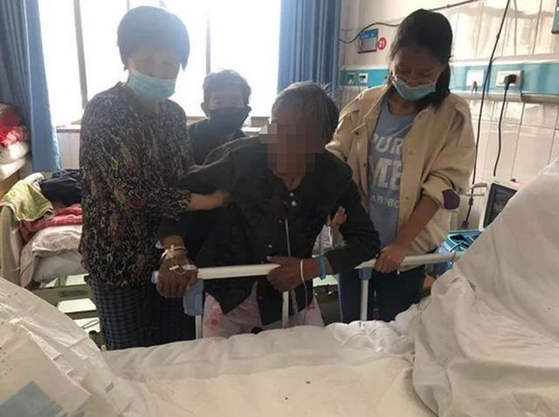 노모를 구덩이에 묻은 중국 남성에게 12년형이 내려졌다. 노모(가운데 검은 옷)는 병원에서도 아들 걱정만 하다가 지난 9월 세상을 떠난 것으로 알려졌다. [왕이망]