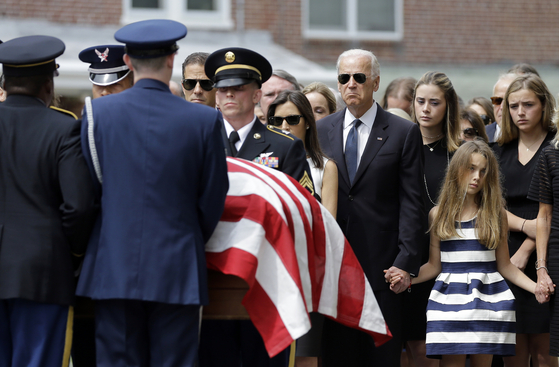 In June 2015, President-elect Joe Biden observes the coffin in which the body of the eldest son, Bo Biden, is enshrined with his family, piled on the American flag and transferred. [AP=연합뉴스]