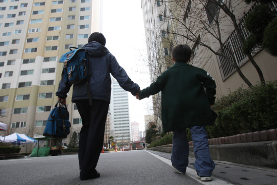 A father walks with a child's hand in an apartment complex in Yongsan-gu, Seoul. [중앙포토]