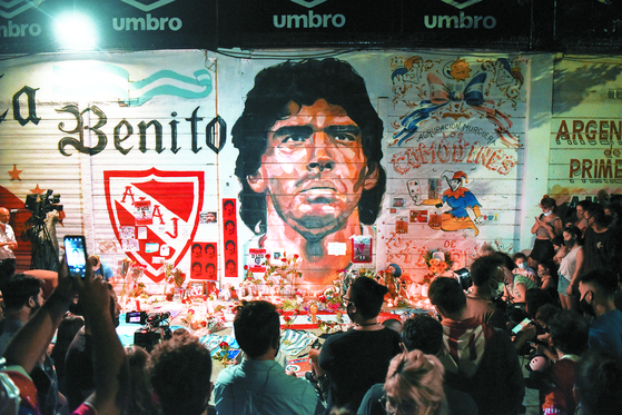 지난 11월 25일(현지시간) 아르헨티나의 수도 부에노스아이레스에 있는 디에고 아르만도 마라도나 스타디움에서 사람들이 마라도나의 벽화를 보고 있다. 로이터=연합뉴스