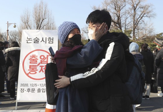 An examinee who came out after completing an essay at Sungkyunkwan University is receiving encouragement from parents.  Reporter Kim Seong-ryong