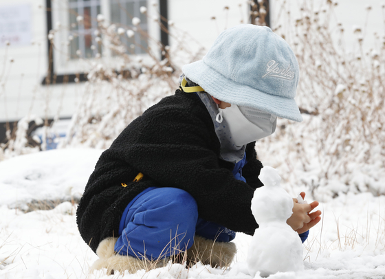 A little boy is making a fern-handed snowman in Namsan, Seoul, on the morning of the 13th.