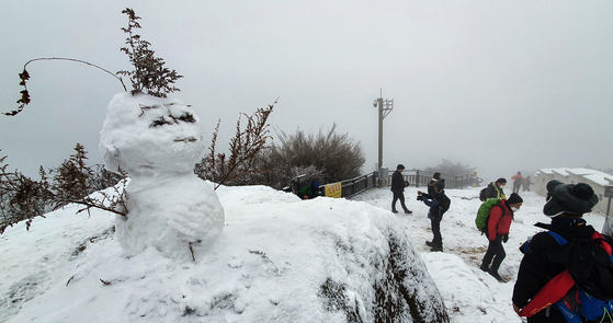 A snowman made from the tallest rock atop Mount Inwang in Seoul on the morning of the 13th. The first heavy snow warning was issued in Seoul this winter.  The snow in the central region stops on the 13th and a strong cold is expected from the 14th. Yunhap news