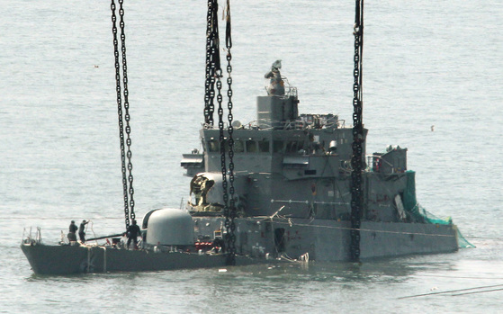 The Cheonan, which was sunk in the waters near Baengnyeongdo Island after a torpedo attack by a North Korean submarine in 2010, is being pulled out of the water. [중앙포토]