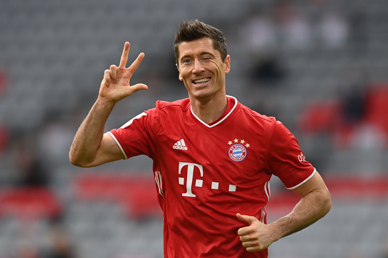 (FILES) In this file photo taken on October 24, 2020 Bayern Munich's Polish forward Robert Lewandowski celebrates scoring the 3-0 goal for his hat-trick during the German first division Bundesliga football match between FC Bayern Munich and Eintracht Frankfurt in Munich, southern Germany. - Bayern Munich striker Robert Lewandowski was named men's player of the year on December 17, 2020 at the FIFA's 'The Best' awards ceremony in Zurich. The 32-year-old Polish forward, top scorer in Europe and winner of the Champions League with Bayern, came out ahead of the other two nominees, Lionel Messi and Cristiano Ronaldo. (Photo by CHRISTOF STACHE / various sources / AFP) / DFL REGULATIONS PROHIBIT ANY USE OF PHOTOGRAPHS AS IMAGE SEQUENCES AND/OR QUASI-VIDEO 〈저작권자(c) 연합뉴스, 무단 전재-재배포 금지〉