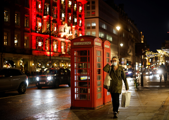 On the 19th (local time), a citizen walks with a mask on the streets of London, England, where a three-phase blockade is in effect. [AFP=연합뉴스]