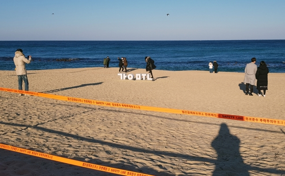 Tourists visiting Gangmun Beach in Gangneung-si, Gangwon-do on the 25th of the Christmas holidays, bypass the access control line and walk along the white sand beach.  Yunhap news