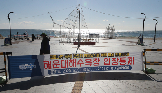 Officials from the Haeundae-gu office in Busan are controlling the access of citizens and tourists to the beach at the entrance of Haeundae Beach, where access is prohibited on the 31st. Reporter Song Bong-geun 20201231