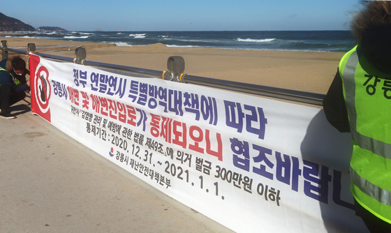 On the afternoon of the 31st, the day before the New Year, Gangneung City, Gangwon city government officials are putting up informational signs around Jeongdongjin Beach to prevent the spread of Corona 19 as tourists flock to it. .  Yunhap news