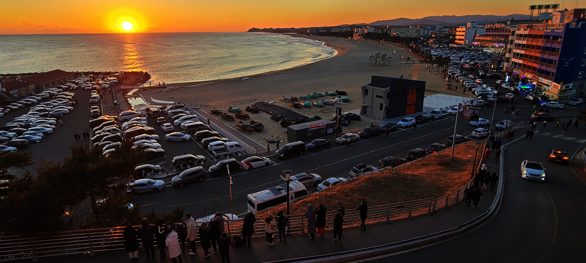 On day 1, the sun rises over the horizon at Naksan Beach in Yangyang, Gangwon-do.  Sunrise vehicles huddle around the controlled sandy beach.  Yunhap news