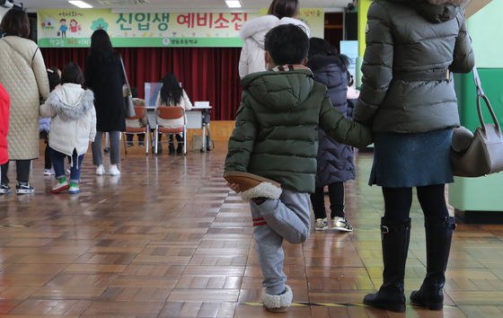 On the afternoon of the 6th, when the preliminary call for primary school was held in 2021, first-year students and parents who visited Yeondong Primary School in Yeonje-gu, Busan, wait for an interview while keeping their distance. Social.  Reporter Song Bong-geun