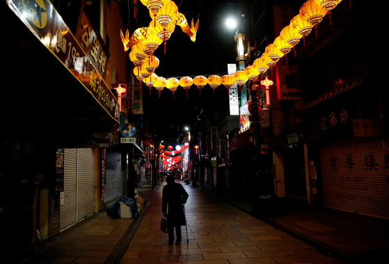 On the 8th, when an emergency was declared in the Japanese metropolitan area, a citizen walks down a shopping street in Yokohama, Kanagawa prefecture, where the lights went out. [로이터=연합뉴스]