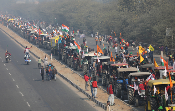 인도의 농부들은 국경일에 트랙터를 운전하여 거리로