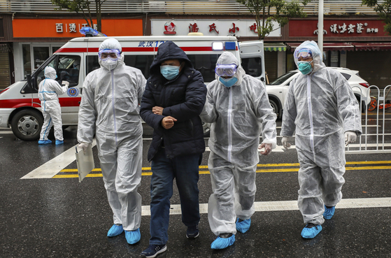 지난해 1월 26일 중국 후베이 성 우한에서 보호 장비를 착용한 의료진이 환자를 후송하고 있다. [AP=연합뉴스]