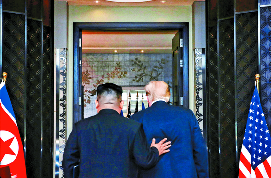 김정은 북한 국무위원장(왼쪽)과 도널드 트럼프 전 미국 대통령이 2018년 6월 12일(현지시간) 싱가포르의 카펠라 호텔에서 북·미 정상회담 공동성명 문서에 서명을 마치고 이동하고 있다.신화사