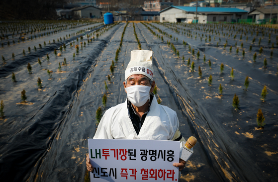 지난달 10일 한국토지주택공사(LH) 직원들이 사들인 경기 시흥 과림동 소재 농지에서 공공주택지구 전국연대대책협의회(공전협) 긴급 기자회견을 마친 한 참가자가 상복을 입은 채 신도시 철회를 촉구하고 있다. 뉴스1