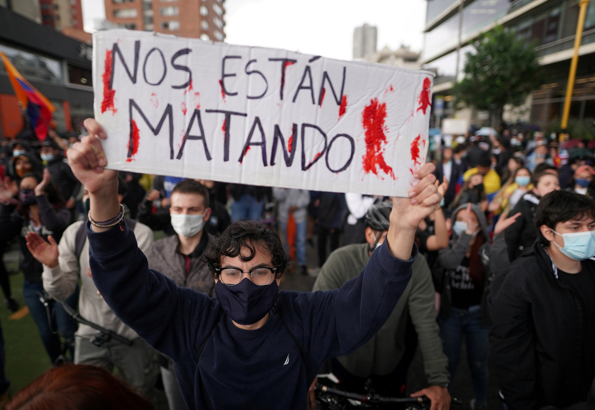 4일 콜롬비아 수도 보고타에서 열린 빈곤과 경찰 폭력에 항의하는 집회에 참석한 시민이 "그들은 우리를 죽이고 있다"는 피켓을 들고 있다. 로이터=연합뉴스