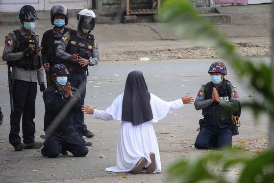 지난 3월 9일 미얀마 북부 카친주에서 안 로사 누 따웅(45) 수녀가 무릎을 꿇고 시위대에게 총을 겨누지 말아달라고 호소하는 모습.[AFP=연합뉴스]
