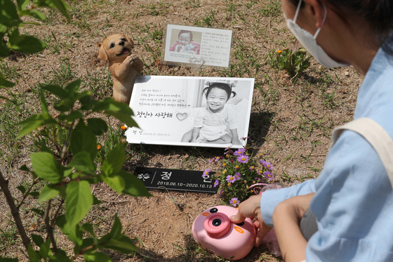 16개월 된 입양아 정인이를 학대해 숨지게 한 혐의를 받는 양부모의 1심 선고 공판이 열린 14일 경기도 양평군 하이패밀리 안데르센 공원묘원에서 참배객이 정인이를 추모하고 있다. 연합뉴스