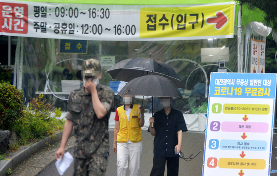 신종 코로나바이러스 감염증(코로나19)이 확산하고 있는 가운데 비가 내린 3일 오후 대전의 한 보건소에 마련된 코로나19 선별진료소를 찾은 시민들이 검사를 받고 이동하고 있다. 프리랜서 김성태