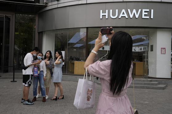 지난 2일 중국 베이징의 화웨이 매장 앞에서 한 시민이 스마트폰을 사진을 찍고 있다. 미국은 트럼프 정부에 이어 바이든 정부에서도 화웨이를 블랙리스트에 올렸다. [AP=연합뉴스]