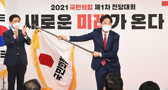 지난 11일 오전 이준석 국민의힘 대표 당선자가 서울 영등포구 여의도동 국민의힘 당사에서 열린 전당대회에서 당기를 흔들고 있다.