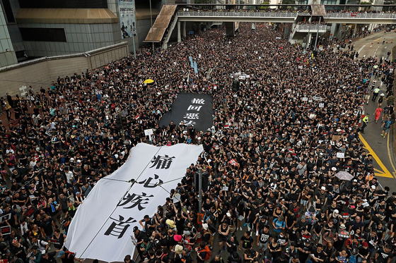 2017년 6월 '범죄인 인도 법안' 철회를 주장하는 홍콩 시위대가 '통심질수'라 쓴 검은색 현수막을 펼치고 있다. [AP/뉴시스]
