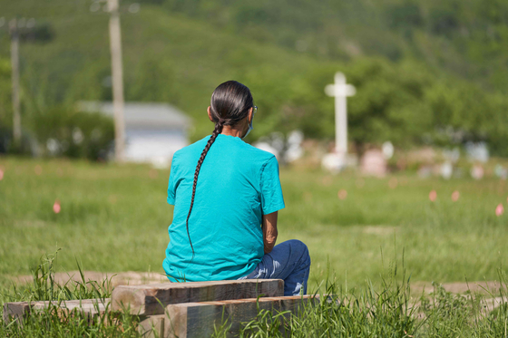 한 원주민 남성이 지난달 25일(현지시간) 원주민 어린이 750여명이 묻힌 것으로 추정되는 캐나다 서스캐처원주 소재 부지에서 기도하고 있다. AFP=연합뉴스