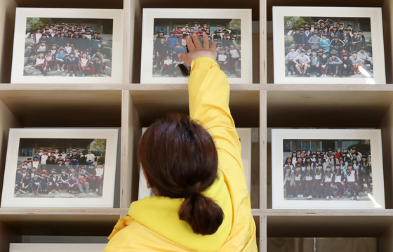 2019년 4월 15일 오전 서울 세종대로 광화문광장 세월호 기억공간에서 한 유가족이 당시 단원고 학생들의 단체사진을 만져보고 있다. 뉴스1