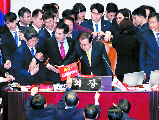 27일 오후 열린 국회 본회의에서 준연동형 비례대표제를 골자로 한 공직선거법 일부 개정 법률안이 재석 167명 중 찬성 156명, 반대 10명, 기권 1명으로 가결됐다. 문희상 국회의장 옆에서 거세게 항의하던 심재철 자유한국당 원내대표가 국회 경위의 제지를 받고 있다. 김경록 기자