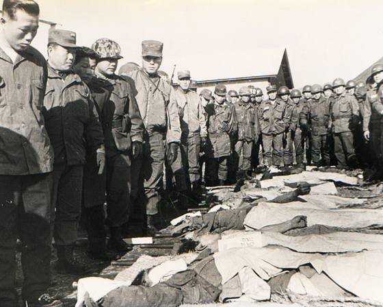 김신조(맨 왼쪽)가 군경에의해 사살된 무장공비 시체를 확인하고 있다. [중앙포토]